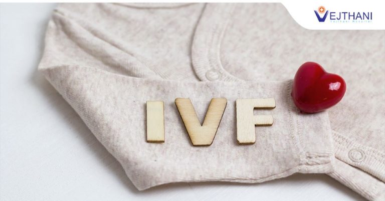 IVF letters and a small heart on the sleeve of a baby outfit.